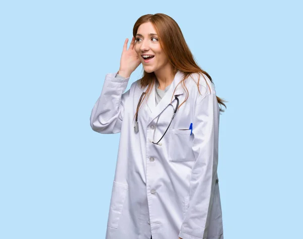 Ruiva Médico Mulher Ouvindo Algo Colocando Mão Orelha Fundo Azul — Fotografia de Stock