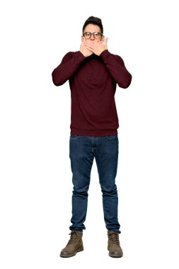 Uygunsuz bir şey izole beyaz arka plan üzerinde söylediğin için el ile ağız kapsayan gözlüklü yakışıklı adam tam uzunlukta atış