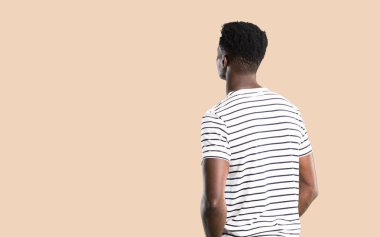 Çizgili gömlekli geri izole koyu sarı arka plan üzerinde seyir ile adam koyu tenli