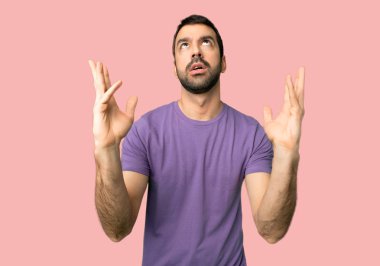 Yakışıklı adam izole pembe bir arka plan üzerinde kötü bir durum tarafından hayal kırıklığına