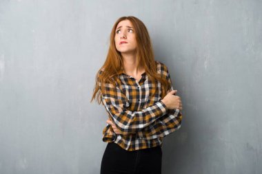 Grunge duvar ile karıştırmayın yüz ifadesi ısırıkları dudak iken genç Kızıl saçlı kız