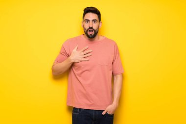 Yakışıklı adam şaşırttı ve doğru bakarken şok sarı duvarın üzerinden