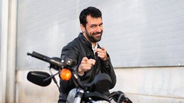 Genç adam önüne işaret eden bir motosiklet üzerinde