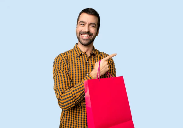 Hombre Con Bolsas Compras Apuntando Con Dedo Hacia Lado Posición — Foto de Stock