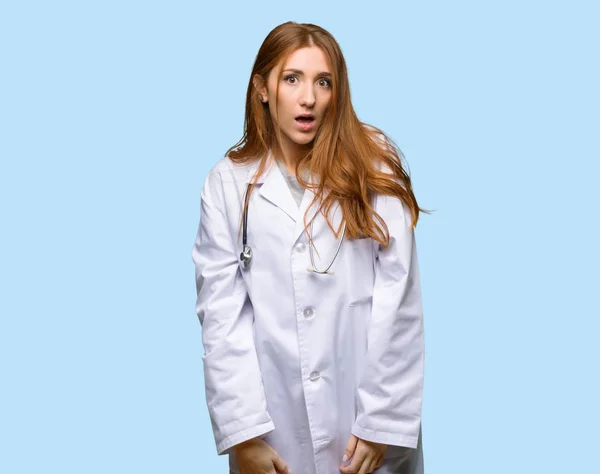 Kızıl Saçlı Doktor Kadınla Sürpriz Izole Mavi Zemin Üzerine Şok — Stok fotoğraf