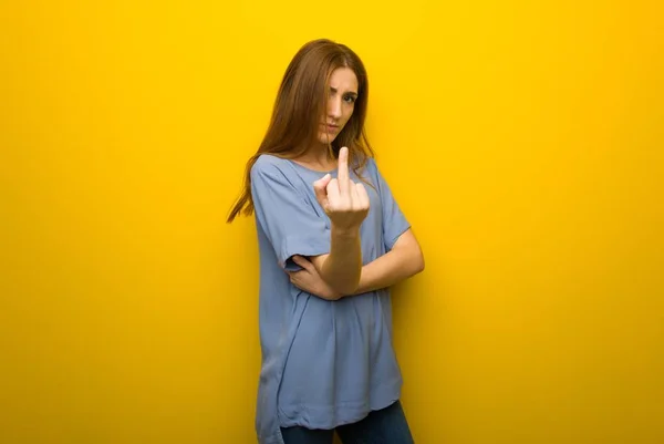 ホーン ジェスチャーを作る黄色の壁の背景の上の若い赤毛の女の子 — ストック写真
