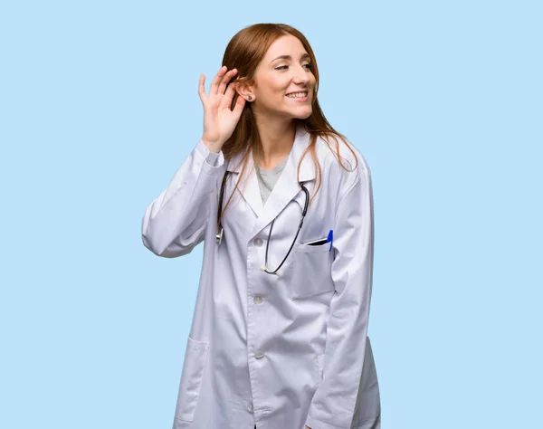 Ruiva Médico Mulher Ouvindo Algo Colocando Mão Orelha Fundo Azul — Fotografia de Stock