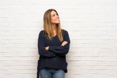 Sarışın kadın tarafına bakarak tuğla duvarın üzerinden