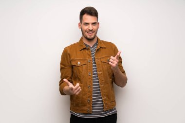 Süre gülümseyen yakışıklı beyaz duvar üzerinde parmak seni işaret