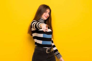 Genç kadın sarı duvarın üzerinden parmak seni kendinden emin bir ifadesiyle işaret