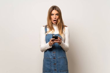 Şaşırttı ve ileti gönderme izole beyaz duvar güzel kadın