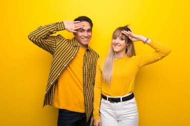 El ile selamlama canlı sarı arka plan üzerinde genç çift