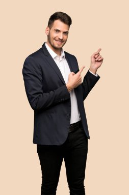 Yakışıklı iş adamı işaret eden parmağa koyu sarı arka plan aşağı