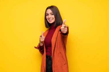 Gülümseyen süre montlu genç kadın parmak seni işaret