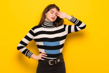 Yorgun ve hasta ifade ile sarı duvarın üzerinden genç kadın