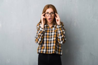 Grunge duvar gözlüklü ve sürpriz genç Kızıl saçlı kız