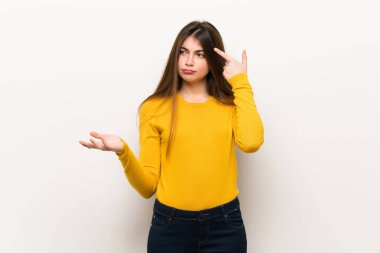 Parmak kafasına koyarak delilik jest yaparak sarı kazaklı genç kadın