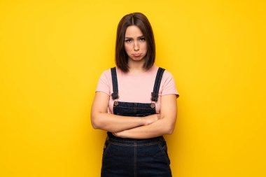 Üzgün ve depresyonda ifade ile sarı duvarın üzerinden genç kadın