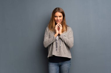 Bir şey entrikacı gri arka plan üzerinde sarışın kadın