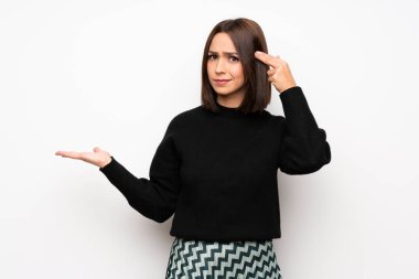 Beyaz duvar parmak kafasına koyarak delilik jest yapma genç kadın