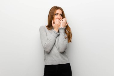 Kızıl saçlı kız beyaz duvar yüzünden biraz gergin ve korkmuş ellerini ağzına koyarak