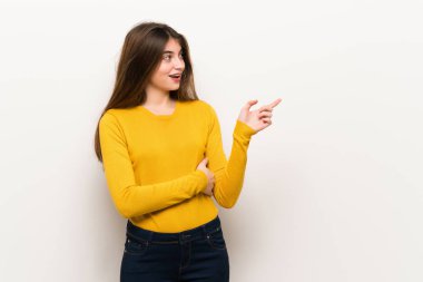 Genç kadın yan yan pozisyonda sarı kazak işaret parmağı