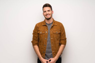 Beyaz duvar önüne bakarak gülen yakışıklı adam