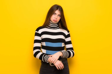 Üzgün ve depresyonda ifade ile sarı duvarın üzerinden genç kadın