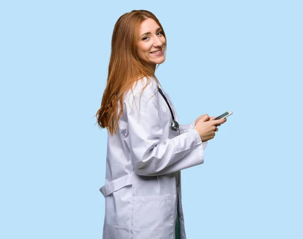 Ruiva Médico Mulher Enviando Uma Mensagem Com Celular Fundo Azul — Fotografia de Stock