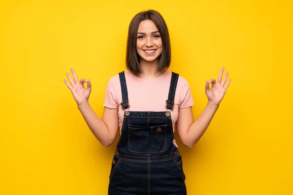 Mujer Joven Sobre Pared Amarilla Mostrando Signo Con Los Dedos —  Fotos de Stock