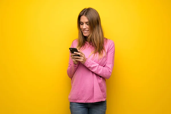 Mujer Con Suéter Rosa Sobre Pared Amarilla Enviando Mensaje Con —  Fotos de Stock