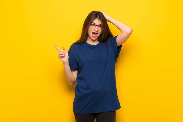 Mujer Joven Con Gafas Sobre Pared Amarilla Apuntando Con Dedo — Foto de Stock