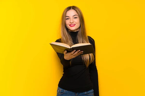 Junge Hübsche Frau Auf Gelbem Hintergrund Hält Ein Buch Und — Stockfoto