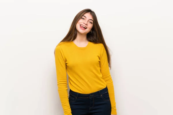面白い顔を持つカメラで舌を示す黄色のセーターを持つ若い女性 — ストック写真