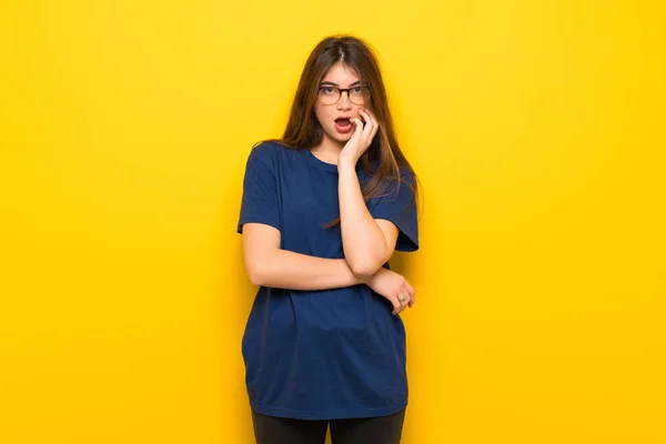 Mujer Joven Con Gafas Sobre Pared Amarilla Sorprendida Sorprendida Mientras —  Fotos de Stock