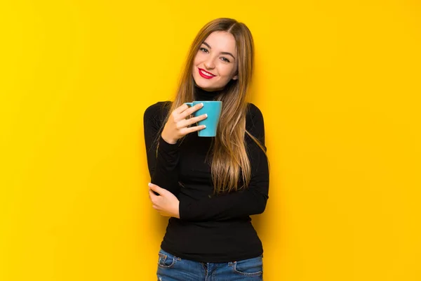 Mooie Jongedame Gele Achtergrond Houdt Van Een Warme Kop Koffie — Stockfoto