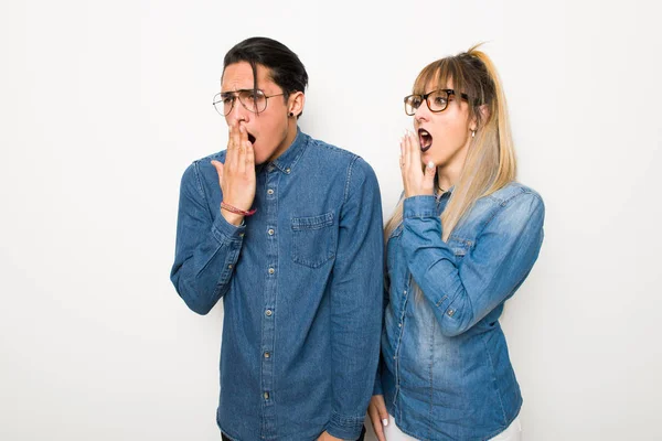 眼鏡をかけた若いカップルがあくびをし 手で大きく開いている口を覆う — ストック写真