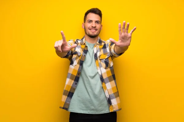 Stilig Man Över Gul Vägg Räknar Sju Med Fingrar — Stockfoto