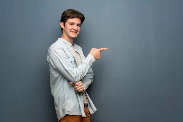 Adolescente Homem Com Jaqueta Jeans Sobre Parede Cinza Apontando Dedo — Fotografia de Stock