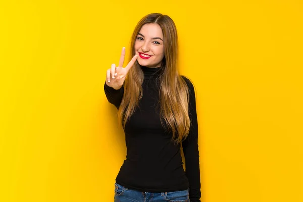 Joven Mujer Bonita Sobre Fondo Amarillo Sonriendo Mostrando Signo Victoria —  Fotos de Stock