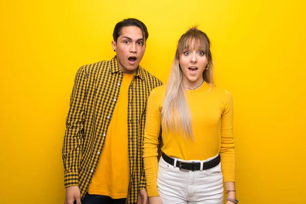 Junges Paar Vor Lebendigem Gelben Hintergrund Mit Überraschung Und Schockiertem — Stockfoto