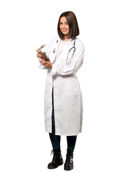 一个年轻医生的女人拿着钱包在孤立的白色背景的全长照片 — 图库照片