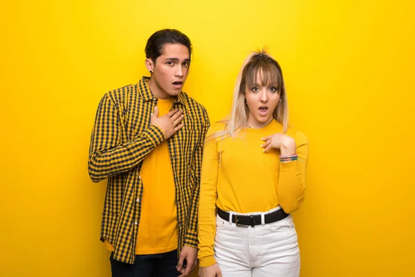 Junges Paar Vor Lebendigem Gelben Hintergrund Überrascht Und Schockiert Während — Stockfoto