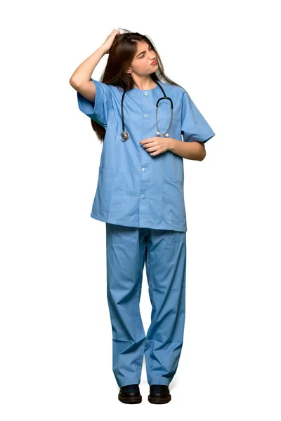 分離の白い背景の上の頭を掻きながら疑問を持つ若い看護師のフルレングスのショット — ストック写真