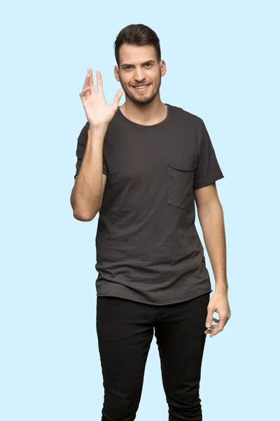 Man Black Shirt Saluting Hand Happy Expression Blue Background — Stock Photo, Image