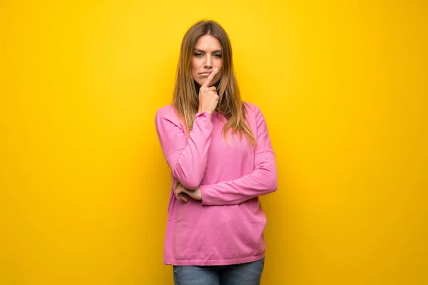 黄色の壁を考えての上のピンクのセーターの女性 — ストック写真
