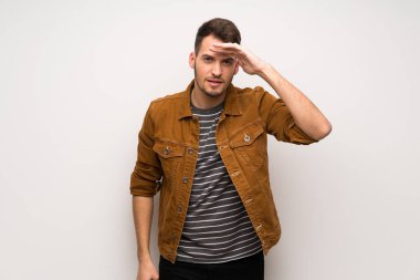 Bir şey bakmak için yakışıklı adam beyaz duvar uzakta el ile seyir üzerinde