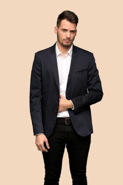 Yakışıklı iş adamı koyu sarı arka plan üzerinde üzgün ve depresyonda ifade ile