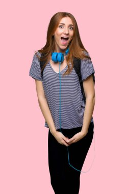 Redhead student woman with surprise and shocked facial expression on isolated pink background clipart