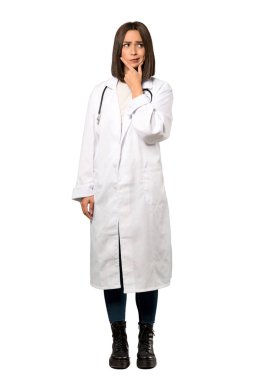 İzole beyaz arka plan üzerinde düşünme bir genç doktor kadın tam uzunlukta bir kadeh